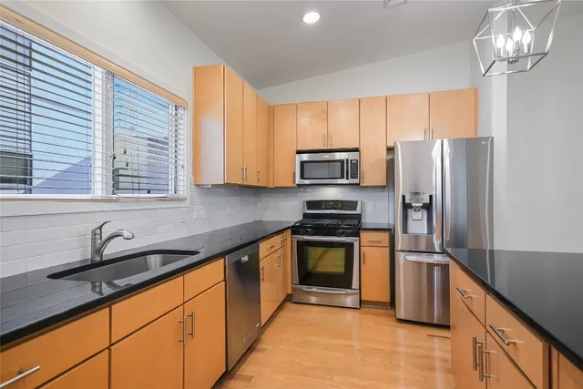 a kitchen with stainless steel appliances granite countertop a sink refrigerator and microwave