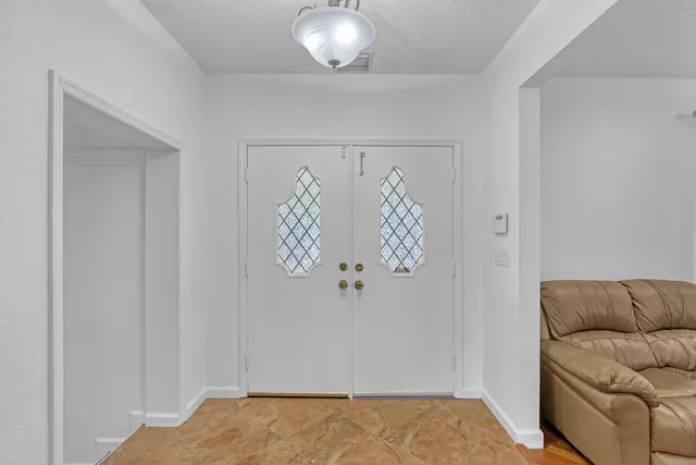 a view of a room that has a bed and glass window