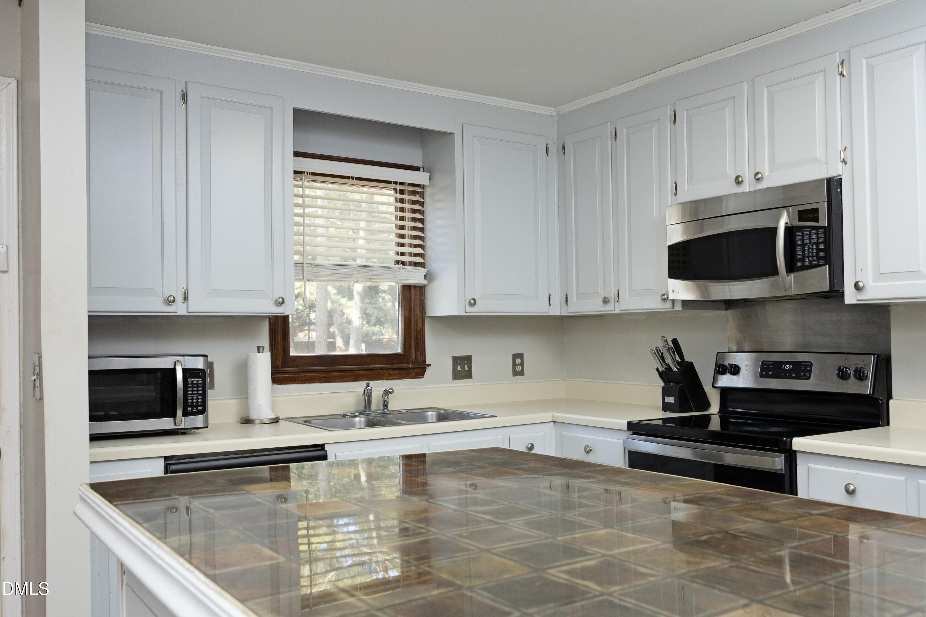5544 Sharpe Drive Raleigh, NC 27612 - Photo 4 of 37 a kitchen with stainless steel appliances granite countertop a stove a sink and a microwave