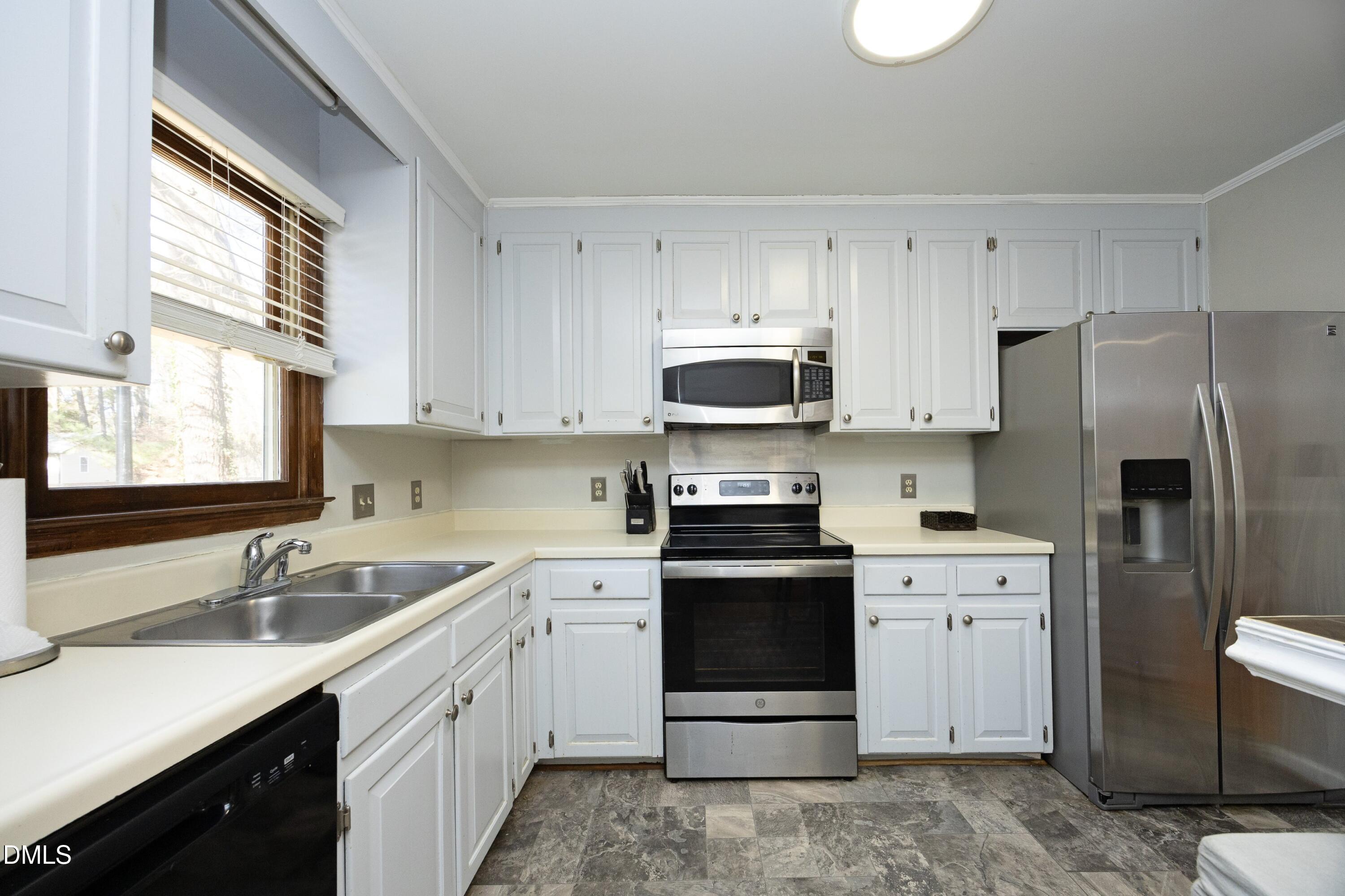 5544 Sharpe Drive Raleigh, NC 27612 - Photo 5 of 37 a kitchen with cabinets stainless steel appliances a sink and a window