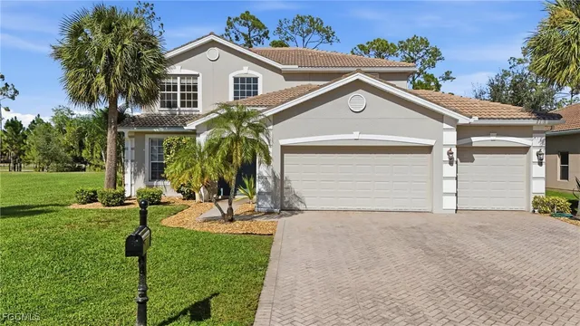 a view of a house with a yard and palm trees