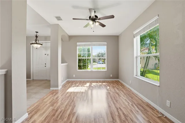 a view of an empty room with a window and wooden floor