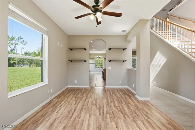 a view of a livingroom with wooden floor a ceiling fan and window