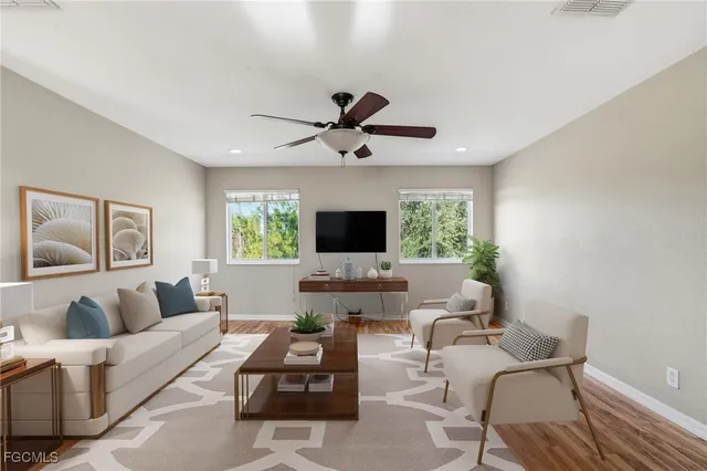 a living room with furniture a flat screen tv and a window
