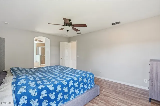 a bedroom with a large bed and wooden floor