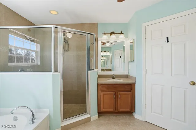 a bathroom with a granite countertop sink a mirror a shower and a bathtub