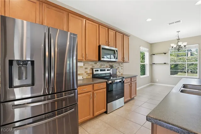 a kitchen with stainless steel appliances granite countertop a refrigerator stove and microwave