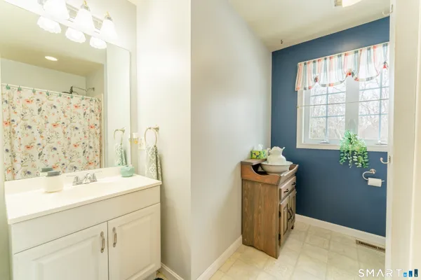 a bathroom with a sink a mirror a vanity and a shower