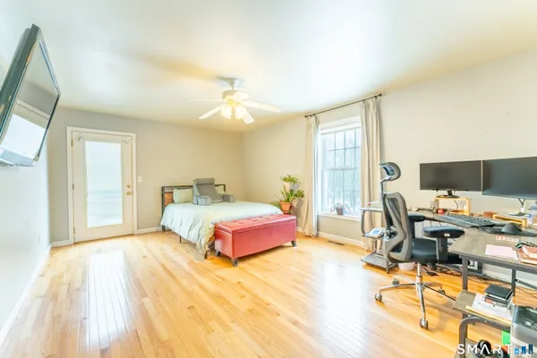 a spacious bedroom with a bed a chandelier and a large window