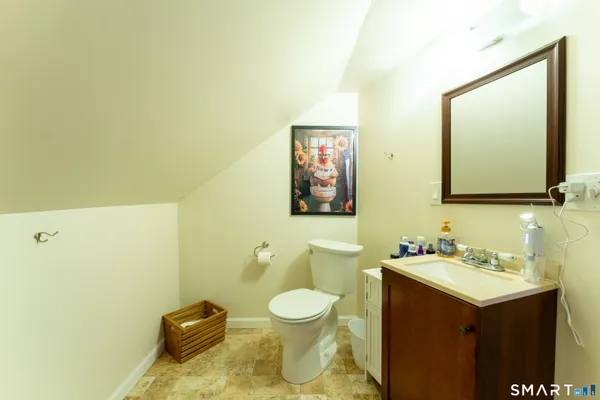 a bathroom with a toilet a sink and mirror