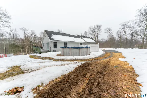 a view of a white house with a yard covered in snow