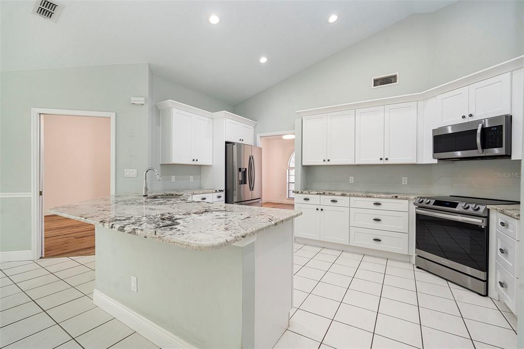 175 Pine Street Homosassa, FL 34446 - Photo 11 of 27 a kitchen with stainless steel appliances granite countertop a stove a sink and a refrigerator