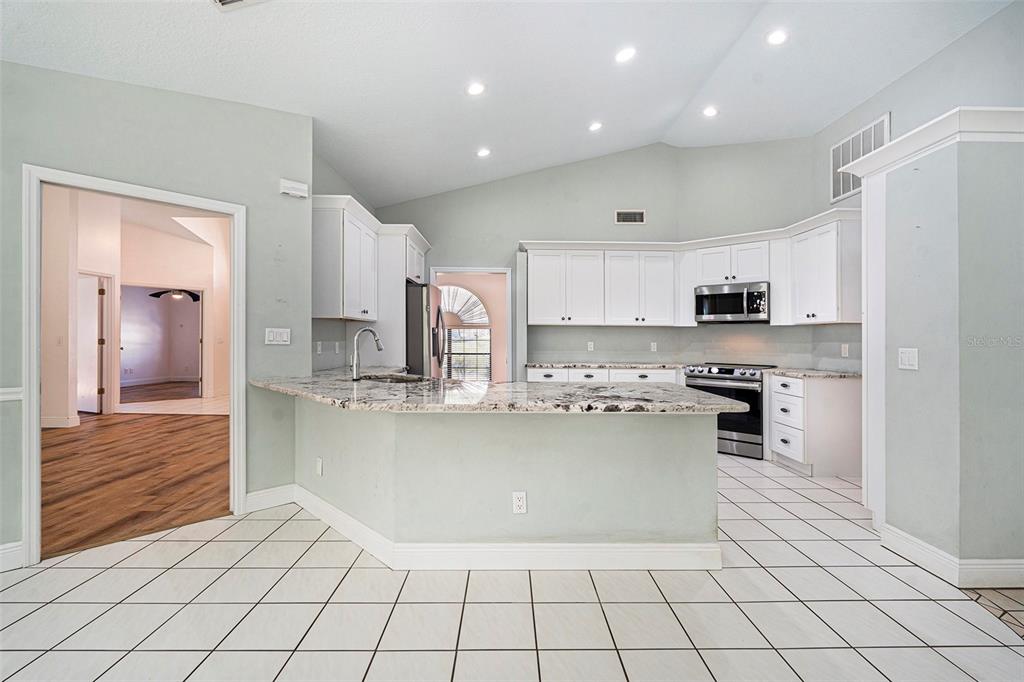 175 Pine Street Homosassa, FL 34446 - Photo 12 of 27 a kitchen with a sink a stove and cabinets