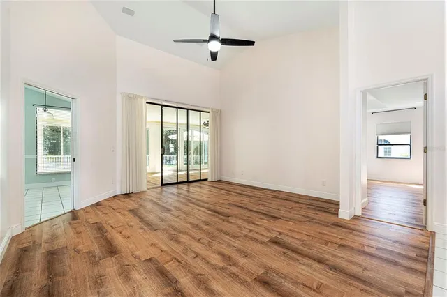 a view of an empty room with a window and wooden floor
