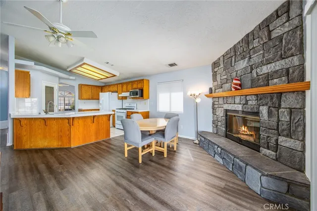 a living room with stainless steel appliances furniture a fireplace and a flat screen tv