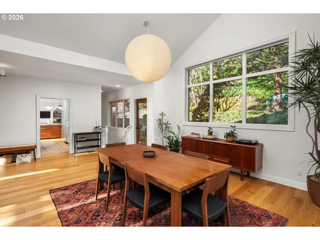a dining room with furniture window and wooden floor