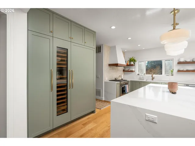 a kitchen with stainless steel appliances kitchen island granite countertop a refrigerator and a sink