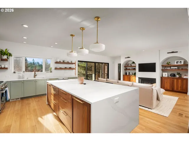a kitchen with stainless steel appliances granite countertop a sink a stove top oven a chimney and a center island