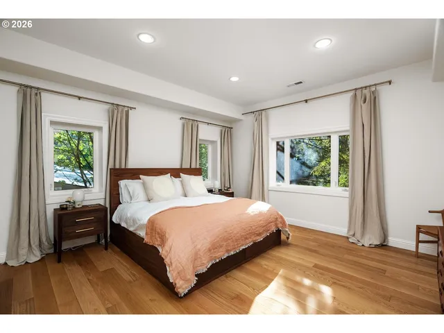 a spacious bedroom with a large bed and a large window