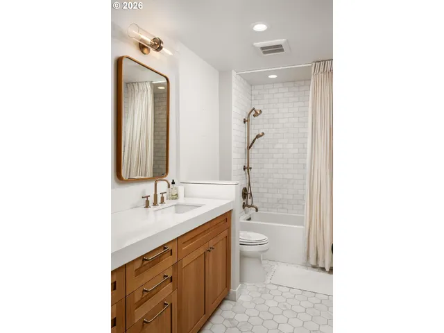 a bathroom with a double vanity sink toilet mirror and bathtub