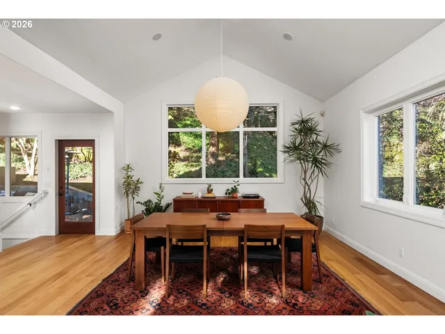 a view of a dining room and livingroom with furniture window and wooden floor