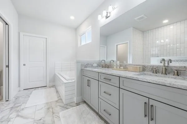 a spacious bathroom with a granite countertop sink a toilet a mirror and vanity