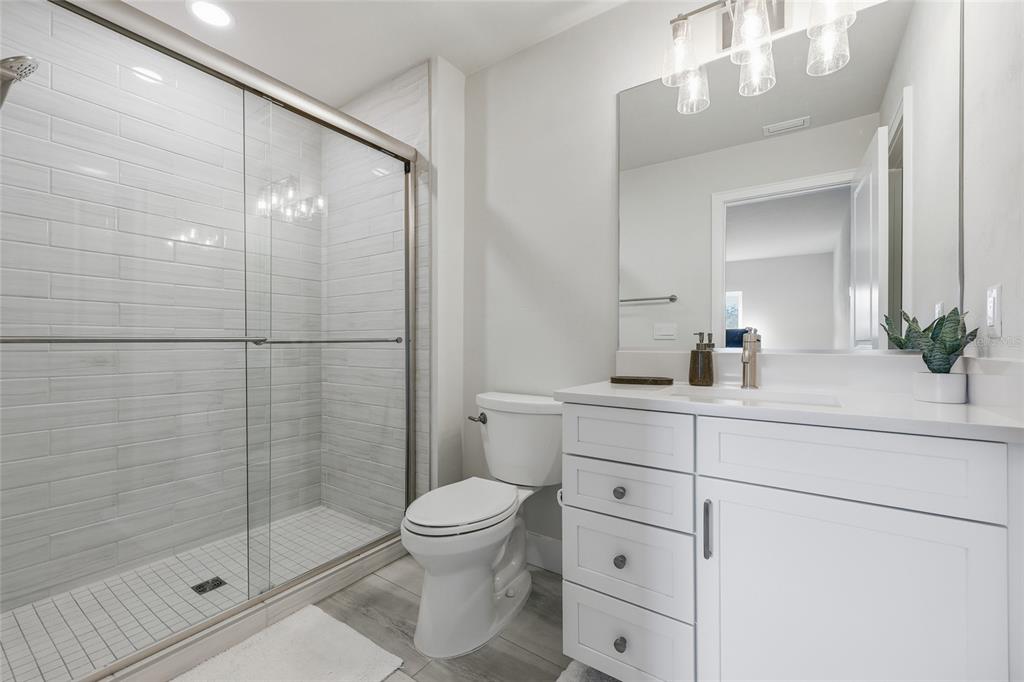 534 Southwest 145th Drive Newberry, FL 32669 - Photo 31 of 38 a bathroom with a shower sink vanity mirror and toilet