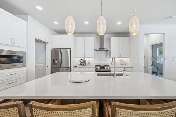 534 Southwest 145th Drive Newberry, FL 32669 - Photo 5 of 38 a kitchen with stainless steel appliances granite countertop a sink a stove a refrigerator and white cabinets with wooden floor