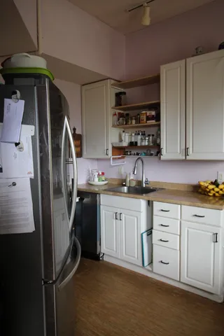 a kitchen with stainless steel appliances granite countertop a refrigerator a stove and white cabinets