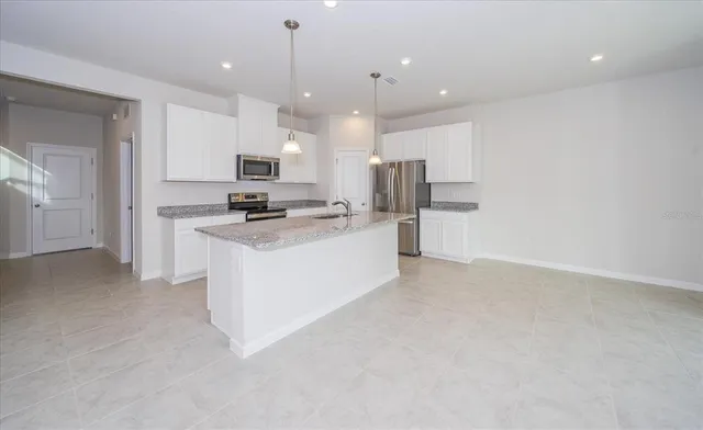 a kitchen with a refrigerator and a stove top oven