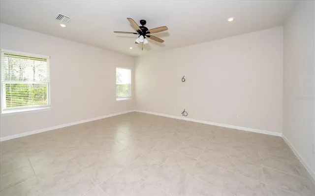 an empty room with a window and a fan