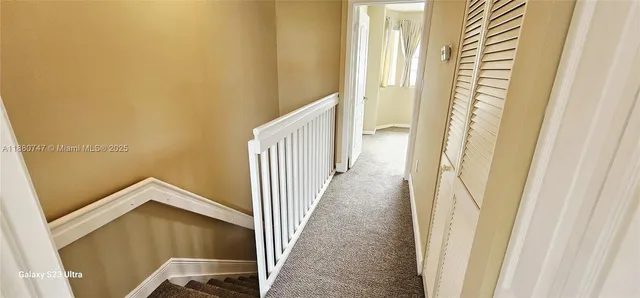 a view of a hallway with wooden floor and door