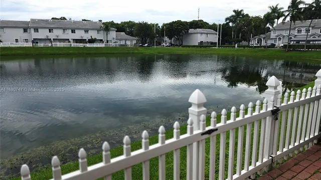a view of a house with a yard and lake view
