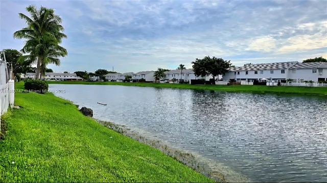 a front view of a house with swimming pool and lake view