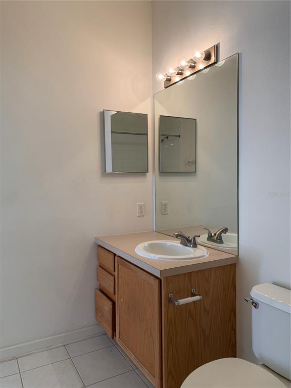 13500 Turtle Marsh Loop, Unit 837 Orlando, FL 32837 - Photo 17 of 30 a bathroom with a toilet sink and mirror