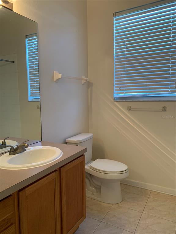 13500 Turtle Marsh Loop, Unit 837 Orlando, FL 32837 - Photo 20 of 30 a bathroom with a sink a toilet and a mirror