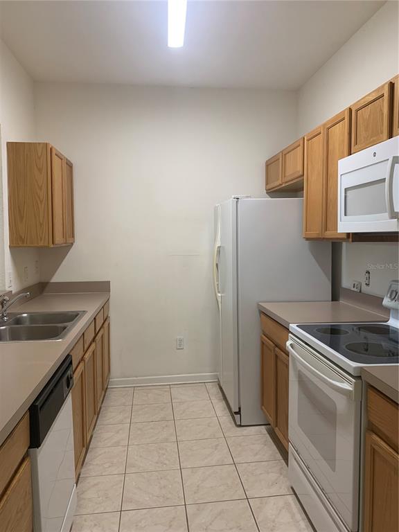 13500 Turtle Marsh Loop, Unit 837 Orlando, FL 32837 - Photo 5 of 30 a kitchen with a sink stove and refrigerator