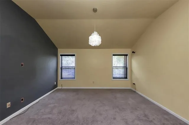 an empty room with windows and mirror