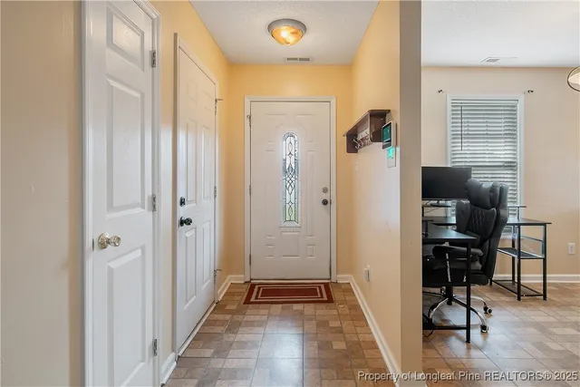 a view of a hallway with bathroom and wooden floor