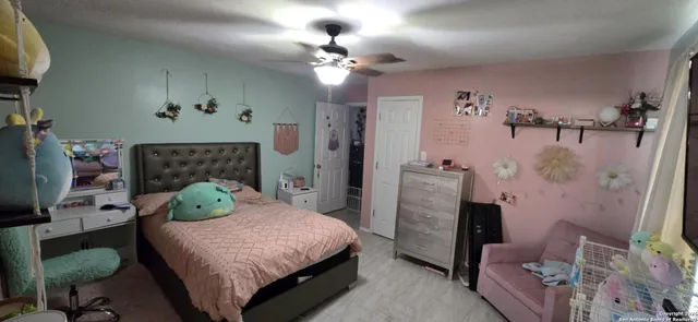 a bedroom with a bed potted plant on dresser and a chandelier