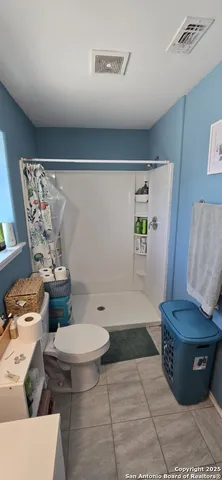 a bathroom with a toilet and a shower curtain