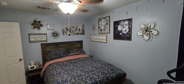 a bedroom with a bed and paintings on the wall