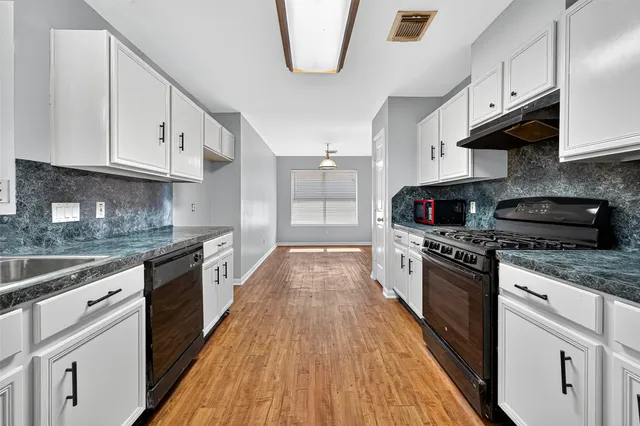a kitchen with granite countertop a sink and cabinets