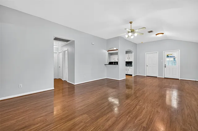 a view of kitchen with wooden floor electronic appliances and stairs