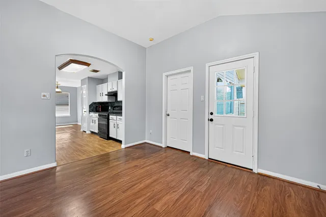 a view of an empty room with wooden floor