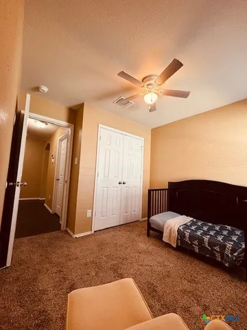 a bedroom with furniture and a ceiling fan