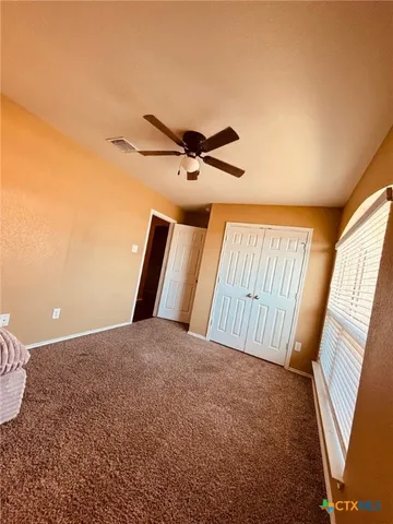 a view of a livingroom with a ceiling fan and wooden floor