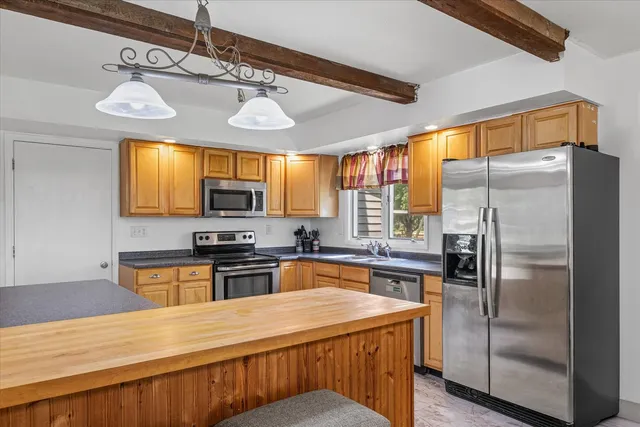 a kitchen with stainless steel appliances granite countertop a refrigerator a stove top oven a sink and dishwasher