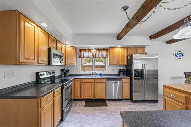 a kitchen with stainless steel appliances granite countertop a sink a stove and refrigerator