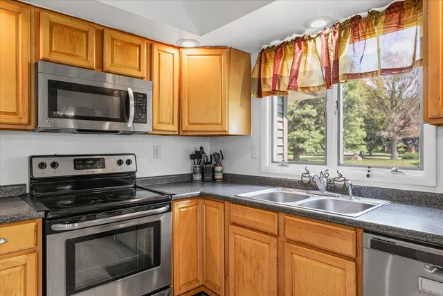 a kitchen with stainless steel appliances a stove sink and microwave